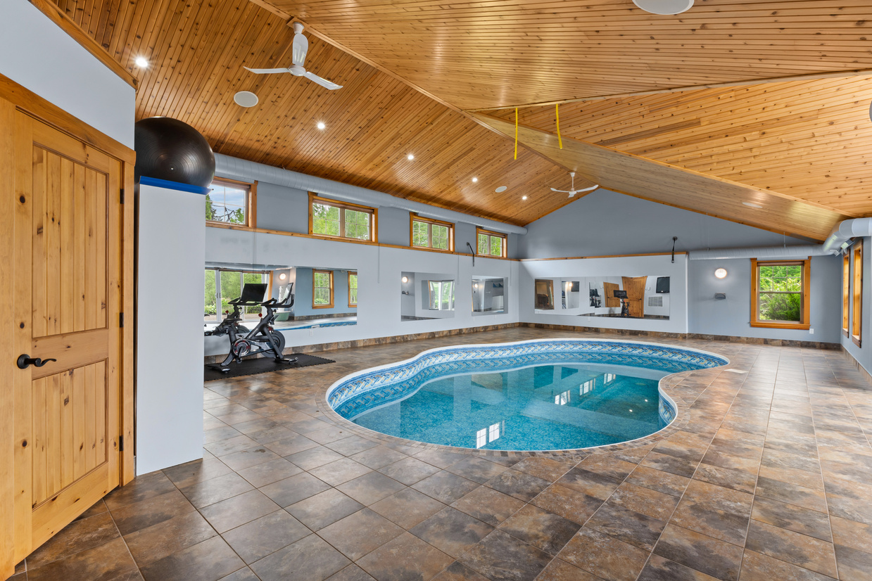 Indoor pool with vaulted wood ceiling overlooking the river