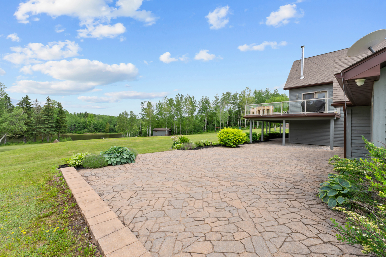 Composite wrap-around deck with glass railings overlooking the river