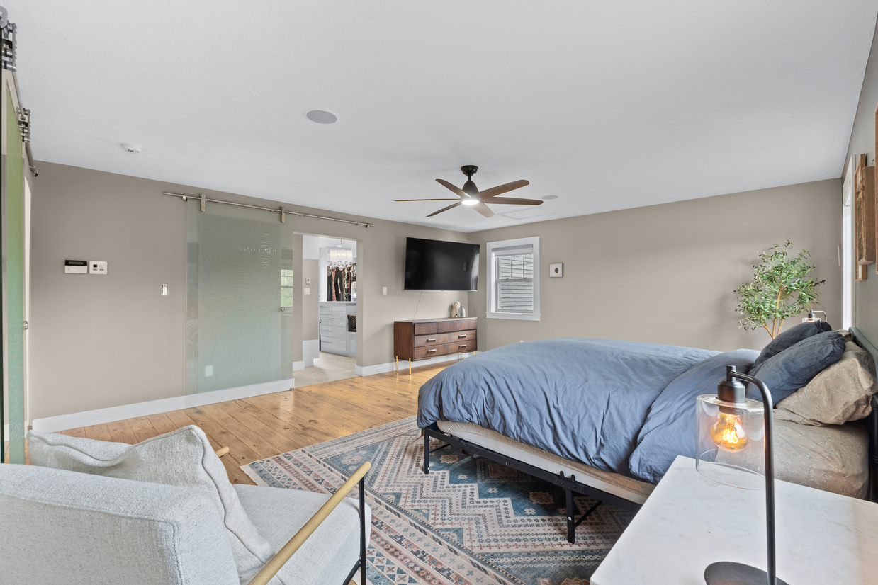 Primary bedroom with glass doors and hardwood floors